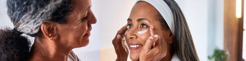 Mature Woman Applying Eye Cream to Another Woman